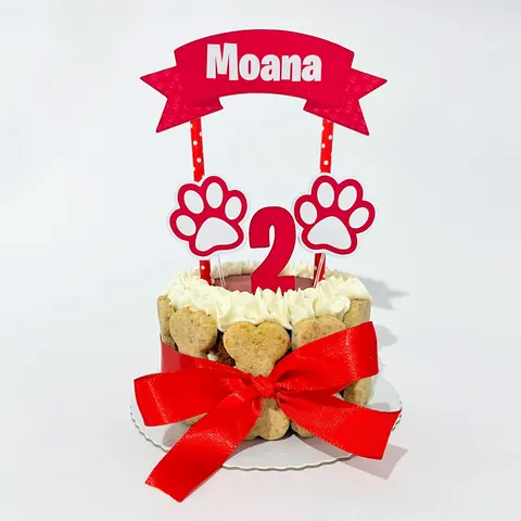 Bolo pet tema Moana com biscoitos ao redor e laço vermelho